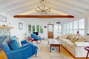 a living room with a couch and a chandelier at 2 Waterfront Cottages in Ocean Point with Dock & Large Yard, Dog friendly in East Boothbay