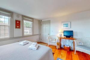 a bedroom with a bed and two chairs and a television at Lovely studio w/full kitchen/free WiFi- next to river/antique shops/restaurants in Wiscasset +6 photos
