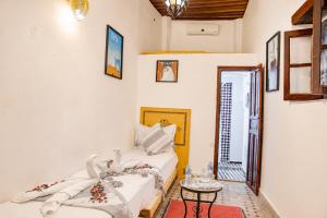 a room with a bed and a table in it at Dar Mayssa Fez in Fez +62 photos