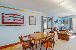 a living room with a wooden table and chairs at Charming, single-level getaway with a full kitchen, fast WiFi, & grassy yard in Boothbay