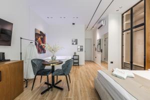 a bedroom with a bed and a table and chairs at Via Mare Jacuzzi Suites by PS in Durrës