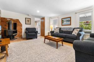a living room with a couch and a fireplace at Bright, spacious getaway with full kitchen, furnished porch & WiFi - near trails in Seal Harbor