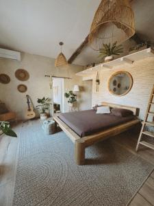 a bedroom with a bed and a ladder and a guitar at Escapade bohème in Bergerac