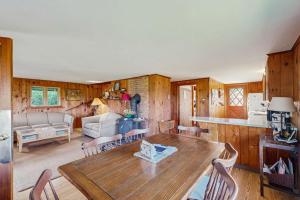a kitchen and living room with a table and chairs at Peaceful coastal cabin with screened porch, water view of the cove, dog-friendly in Owls Head +21 photos