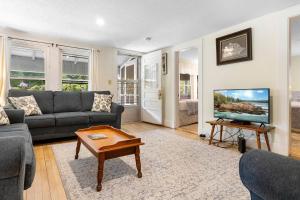 a living room with a couch and a tv at Bright, spacious getaway with full kitchen, furnished porch & WiFi - near trails in Seal Harbor