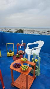 a table with a plate of fruit and a chair at Super sea promenade apartment in El Mîna