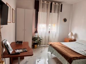 a bedroom with a bed and a table with a laptop at VILLA GIOVANNA in Bergamo
