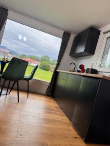 eine Küche mit großem Fenster und einem Tisch in der Unterkunft Tiny House ROA in Recea