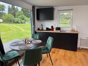 eine Küche und ein Esszimmer mit Tisch und Stühlen in der Unterkunft Tiny House ROA in Recea + 15 Fotos
