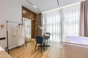 a bedroom with a tub and a table and a bed at Via Mare Jacuzzi Suites by PS in Durrës +97 photos