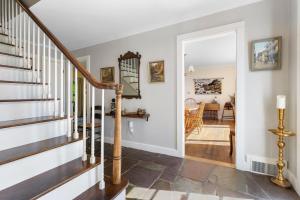 a staircase in a home with white walls at Dog-friendly oceanfront home with private shorefront, two fireplaces, & firepit in Steuben