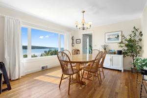 a dining room with a table and chairs and a large window at Dog-friendly oceanfront home with private shorefront, two fireplaces, & firepit in Steuben +34 photos