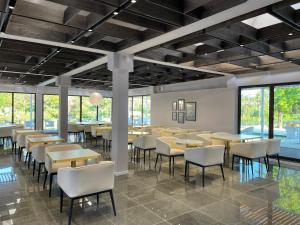 a dining room with tables and chairs and windows at Resort Cupidon Neptun in Neptun