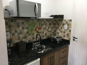 a kitchen with a sink and a sign on the wall at Private Suite with Kitchen & Pool Access in Itapetininga