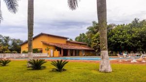 a house with a swimming pool and palm trees at Private Suite with Kitchen & Pool Access in Itapetininga