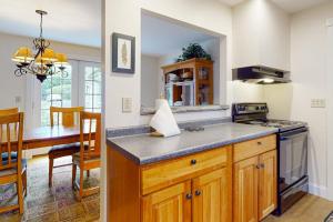 a kitchen with a counter and a dining room at Gorgeous, walkable home with water view, deck & washer/dryer - snowbird-friendly in Camden +22 photos