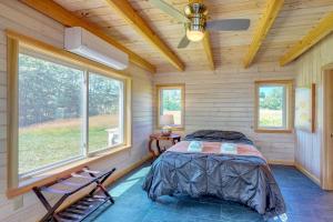 ein Schlafzimmer mit einem Bett in einem Zimmer mit Fenstern in der Unterkunft Bayfront home with gorgeous water views, dock, outdoor patio, fireplace in Bowdoinham