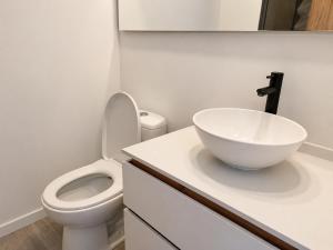 a bathroom with a white sink and a toilet at Apartaestudio Centro Internacional UTEK in Bogotá +3 photos