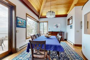 a dining room with a blue table and chairs at Private Oceanfront Home -- 2 Fireplaces, 4 Decks & Grill, Dog-friendly in East Boothbay