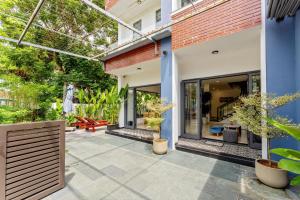 an outdoor patio with glass doors and plants at Buddy January Villa in Hoi An