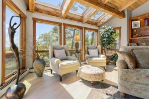 a living room filled with furniture and windows at Elegant ocean view home with breathtaking views, private hot tub & large deck in Rockport +21 photos