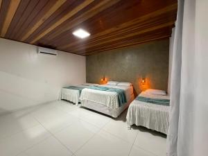 a room with two beds in a room at Casa Pé da Serra in Estivado