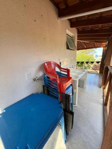 two red and blue chairs sitting next to a table at Casa Pé da Serra in Estivado