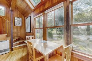 a dining room with a table and some windows at Waterfront Paradise with Dock, Big Yard, Sundeck & Epic Bay Views | Dog-Friendly in Boothbay