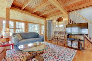 a living room with a blue couch and a glass table at Charming Bayview Cottage with Deck, Firepit, Garden - 200 in East Harpswell