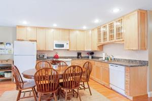 a kitchen with a table and chairs and a white refrigerator at Dog-friendly home in great locale close to the ocean with yard, streaming, W/D in Tremont +12 photos