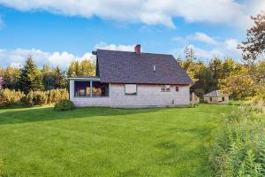 a house with a large yard with green grass at Peaceful coastal cabin with screened porch, water view of the cove, dog-friendly in Owls Head