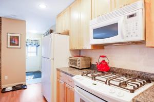 a kitchen with a white stove and a microwave at Dog-friendly home in great locale close to the ocean with yard, streaming, W/D in Tremont