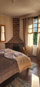 a bedroom with a bed and a brick wall at Aconchego Mineiro in Visconde De Maua