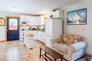 a living room with a couch and a table and a kitchen at Two-story home steps from Laite Beach - stroll to the harbor, 1 dog welcome in Camden