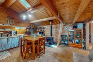 a kitchen with a wooden table and a stove at The Cottage - Peaceful 32-Acre Lakefront Getaway - Canoe, Firepit & Big Deck in Franklin