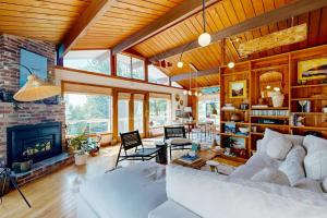 a living room with a white couch and a fireplace at Stunning artist's retreat with ocean view & amazing deck, near Reid State Park in Georgetown
