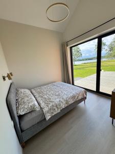 a bedroom with a bed and a large window at Järvemetsa Stay in Dejevo