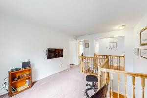 a living room with a chair and a television on a wall at Idyllic waterfront home with furnished deck, grill, sweeping views & private W/D in Waldoboro