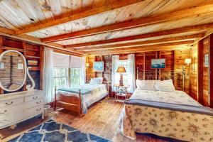 a bedroom with a bed and a desk and a mirror at Cozy, Waterfront Cabin-Style Gem with Private Dock and Lovely Views in East Harpswell