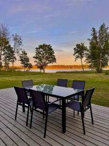 a table and chairs on a deck with a field at Järvemetsa Stay in Dejevo