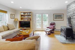 a living room with a couch and a fireplace at Gorgeous, walkable home with water view, deck & washer/dryer - snowbird-friendly in Camden