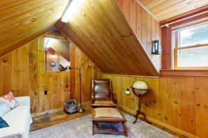 a room with wooden walls and a chair and a window at Historic Boothbay Harbor cottage with antique decor, washer/dryer & deck in Boothbay Harbor