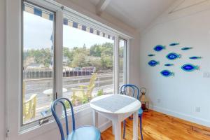 a dining room with a table and chairs and a window at Oceanfront Cottage & Studio on Mill Cove w/ Water Views, Deck - Walk Downtown in Boothbay Harbor