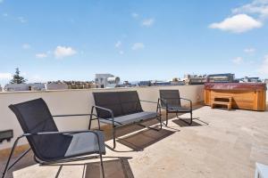 three chairs and a piano on a roof at Stylish Penthouse with private Pool andJacuzzi in Naxxar