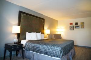 a hotel room with a large bed with two lamps at Horizon Inn Norcross in Norcross