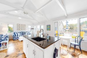a kitchen with a counter and a table and chairs at Oceanfront Cottage & Studio on Mill Cove w/ Water Views, Deck - Walk Downtown in Boothbay Harbor