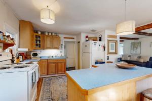 a kitchen with a white refrigerator and a counter top at Charming Boothbay Harbor cottage with partial AC, full kitchen, and sun room in Boothbay Harbor +18 photos