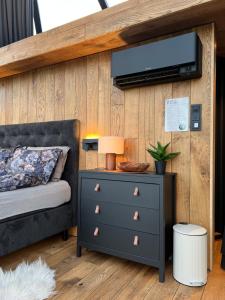 a bedroom with a bed and a dresser with a tv on a wall at Lofoten Aurora Dome in Hanøya