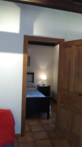 a small bedroom with a bed and a door at Apartamento Mercedes in Cobisa