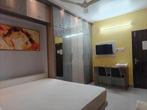 a bedroom with a bed and a tv and a desk at NHM Stays in Garui +6 photos